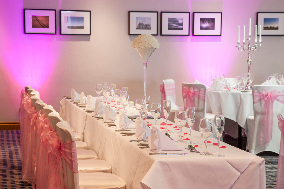 table setting with floral arrangement, cakes, bride and groom cupcakes.